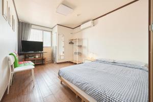 a bedroom with a bed and a flat screen tv at Travel Home in Seoul