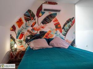 a bedroom with a blue bed with a mural at Ma Cabane in Mouret