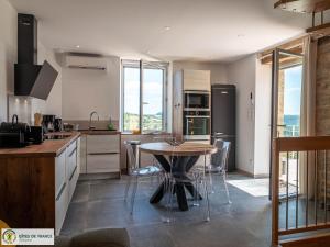 a kitchen with a table and some chairs in it at Ma Cabane in Mouret