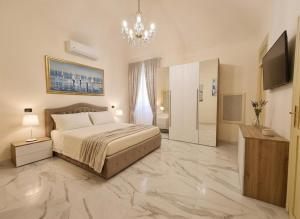 a large bedroom with a bed and a chandelier at Antica Dimora Donna Emma in Carini +13 photos