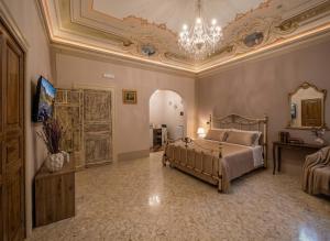 a large bedroom with a bed and a chandelier at Antica Dimora Donna Emma in Carini