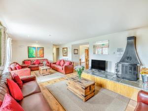 a living room with red furniture and a fireplace at The Cider Barn - Hggl in Luton