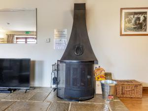 a fireplace in a living room next to a tv at The Cider Barn - Hggl in Luton