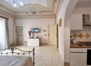 a room with a bed and a kitchen with a table at Antica Dimora Donna Emma in Carini