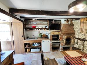 a kitchen with a stove and a stone fireplace at Мехса in Svetoslav