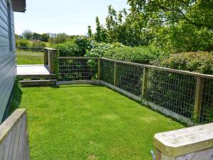 a garden with a fence and a lawn at Sunny Skies in St Austell +12 photos