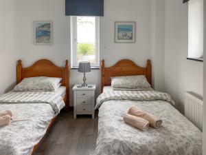 a bedroom with two beds and a window at Sunny Skies in St Austell