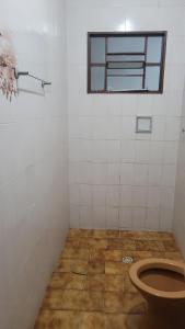 a bathroom with a toilet and a window at Entire house in Mococa +21 photos