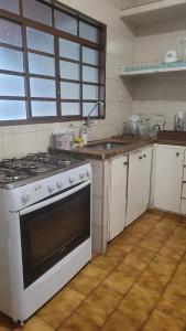 a kitchen with a white stove and a sink at Entire house in Mococa