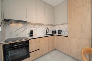 a kitchen with white cabinets and a black appliance at Smash A - Apartments with Private Pool in Novalja