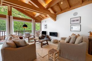 a living room with two couches and a wooden ceiling at Chalet Villarenger in Saint-Martin-de-Belleville