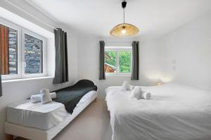 a white bedroom with two beds and a window at Chalet Villarenger in Saint-Martin-de-Belleville