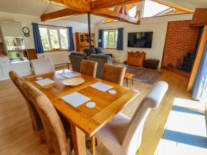 a dining room and living room with a wooden table and chairs at 80 Pentney Lakes in King's Lynn