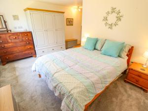a bedroom with a large bed and a dresser at 80 Pentney Lakes in King's Lynn