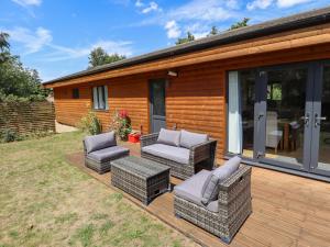 a patio with wicker furniture on a wooden deck at 80 Pentney Lakes in King's Lynn