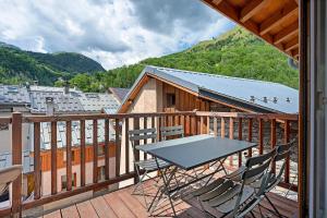 a table and chairs on a balcony with a mountain at Chalet Villarenger in Saint-Martin-de-Belleville