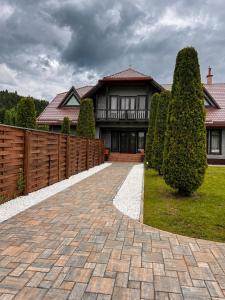 a house with a fence and a brick driveway at Spring Apartments in Gheorgheni