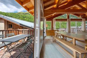 a dining room with a table and benches on a deck at Chalet Villarenger in Saint-Martin-de-Belleville