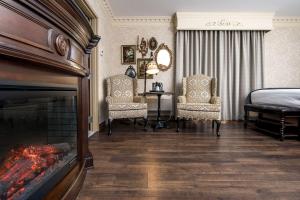 a bedroom with a fireplace and a bed and chairs at Fulton Steamboat Inn in Lancaster