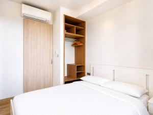 a bedroom with a white bed and a closet at Sky Park Laguna 2BR Condo with Balcony in Laguna Phuket