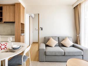 a living room with a couch and a table at Sky Park Laguna 2BR Condo with Balcony in Laguna Phuket