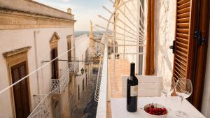 a bottle of wine sitting on a table on a balcony at 21mq Suite Jacuzzi in Ostuni