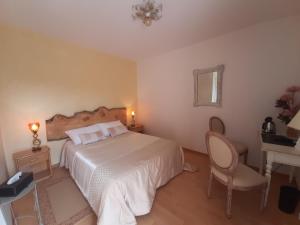 a bedroom with a bed and a desk and a chair at Ô Reflet du Lac in Groléjac