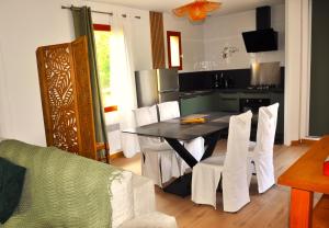 a kitchen and dining room with a table and chairs at Ô Reflet du Lac in Groléjac
