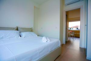 ein weißes Bett mit Handtüchern darauf in einem Zimmer in der Unterkunft Path House by Wonderful Italy in Riposto + 29 Fotos