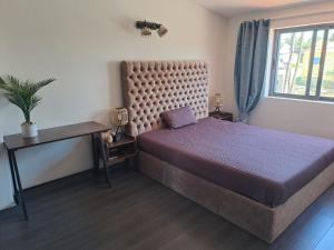 a bedroom with a large bed and a window at Villa Ocean Waves in Aroeira