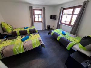 a room with two beds and two windows at GR ooms Rents in Gemmrigheim