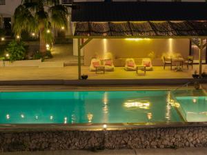 ein Pool bei Nacht mit einer Couch und einem Tisch in der Unterkunft Agoulos Beach Hotel in Argassi