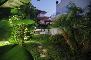 ein Garten mit Palmen vor einem Gebäude in der Unterkunft Path House by Wonderful Italy in Riposto