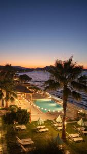 Blick auf ein Resort mit Pool und Palme in der Unterkunft Agoulos Beach Hotel in Argassi