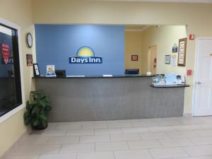 a day inn sign on a counter in a lobby at Days Inn by Wyndham Seaworld Lackland AFB in San Antonio