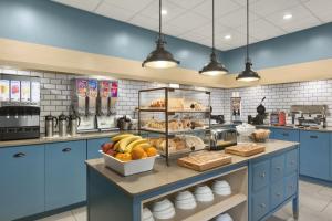 una cocina con armarios azules y una barra con comida en Country Inn & Suites by Radisson, Summerville, SC, en Summerville