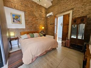 a bedroom with a large bed and a brick wall at El Centurión del Camino Real in Villa Tulumba