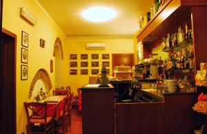 a restaurant with a kitchen and a bar with tables at Hotel Major in Genoa
