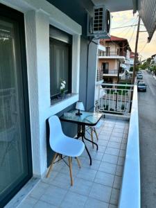 a table and a chair on the balcony of a building at Annaria in Leptokarya
