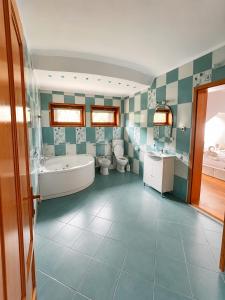 a bathroom with two toilets and a tub and a sink at Spring Apartments in Gheorgheni +18 photos
