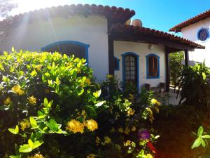 a small house with yellow flowers in front of it at Pousada Aldeia dos Ventos in São Pedro da Aldeia