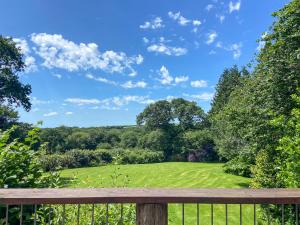 a view from the deck of a house with a green field at Sunset in St Austell