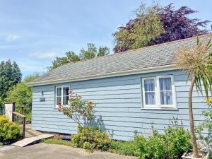 a blue house with a window and some bushes at Sunset in St Austell +9 photos