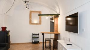 a living room with a table and a tv on a wall at 21mq Suite Jacuzzi in Ostuni