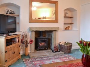 a living room with a fireplace and a mirror at Keldholme Cottage 1 - Uk10992 in Kirkbymoorside