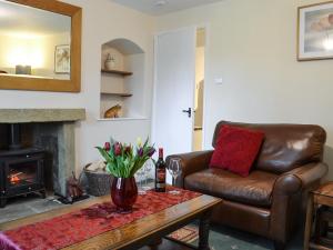a living room with a leather couch and a coffee table at Keldholme Cottage 1 - Uk10992 in Kirkbymoorside +8 photos