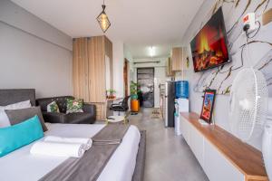 a living room with a white bed and a couch at Studio Apartment with balcony in Ngara in Nairobi