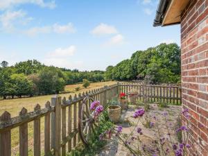 a wooden fence with flowers next to a field at Coblye Barn in Battle