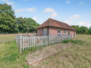 an old brick house with a fence in a field at Coblye Barn in Battle +13 photos
