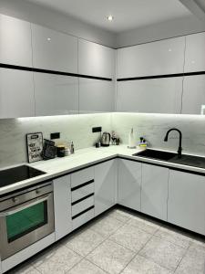a kitchen with white cabinets and a sink at Annaria in Leptokarya
